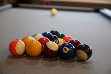 Pool balls lined up to be broken on a billiards table