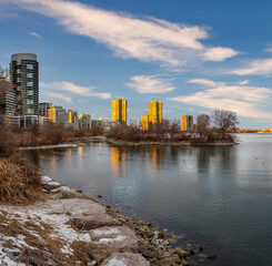 Obraz premium City skyline reflected in calm winter water.