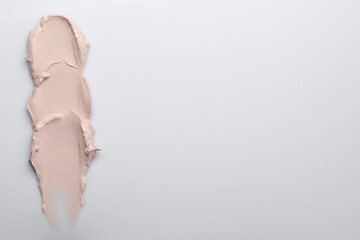 Cream isolated on white, top view. Sample of cosmetic product