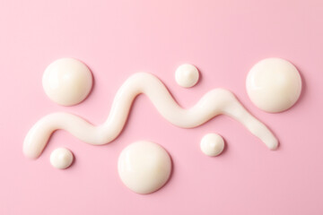 Cream on pink background, flat lay. Samples of cosmetic product