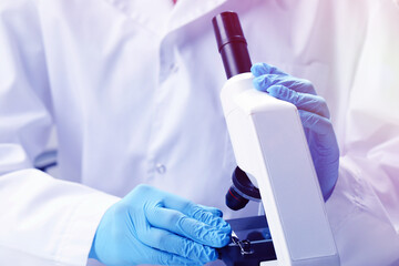 Scientist working with microscope in laboratory, closeup