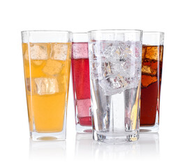 Soda water of different flavors with ice cubes in glasses isolated on white