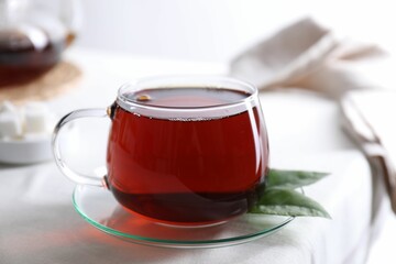 Refreshing black tea in cup on light table, closeup