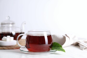 Refreshing black tea in cup on light table