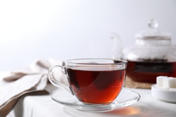 Refreshing black tea in cup on light table