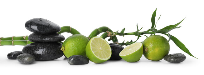 Spa composition with limes, massage stones and bamboo stems isolated on white
