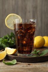 Fresh iced cola with mint and lemons on wooden table
