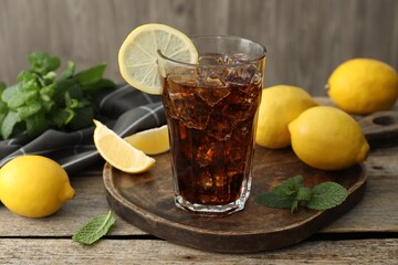 Fresh iced cola with mint and lemons on wooden table, closeup