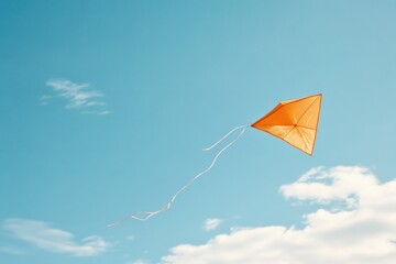 Bright orange kite soaring in clear blue sky with white clouds