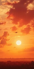 Obraz premium airplane crossing the sky at sunset. The rich oranges and reds of the setting sun provide a stunning backdrop,