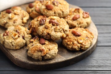 Tasty cookies with nuts on dark wooden table, closeup