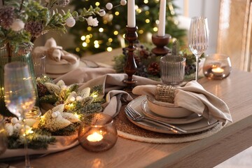 Christmas place setting with festive decor on wooden table in room