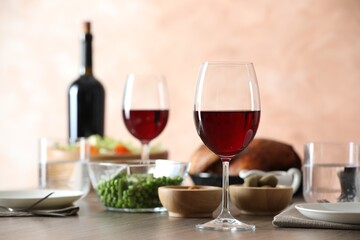Red wine and delicious dinner served on wooden table