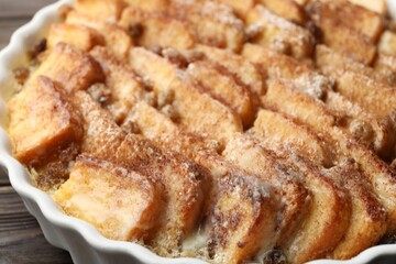 Delicious bread pudding with raisins and cinnamon on table, closeup