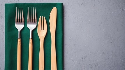 Sustainable Travel Concepts. Cutlery displayed on a green napkin against a gray background.