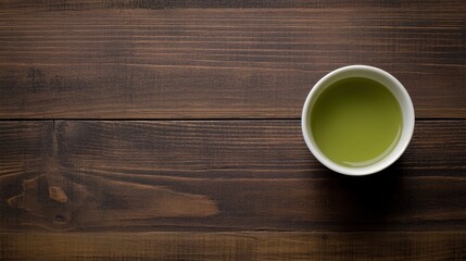 A cup of matcha tea, placed on a dark wooden surface, with a generous space for text