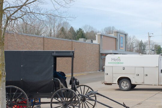Black Amish buggy no horse in parking lot of an Aldi Grocery store. Editorial Use Only, Wooster, Ohio USA,  January 30, 2025.
