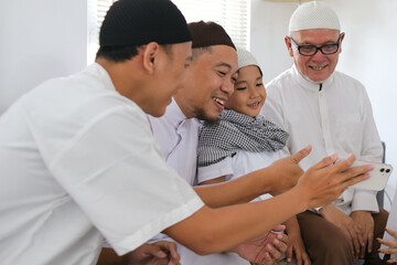 Muslim Family Bonding On Eid Celebration. Multi Generation Family Greeting Others On Video Call. 