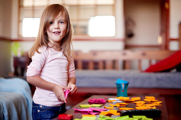 Fototapeta premium Portrait, girl and child in home with sticky note for remote learning, education or writing skills. School, assessment and happy kid with stationery for creativity, drawing or development for project