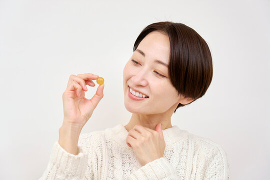 のど飴を持つ女性　白背景