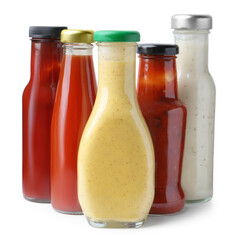 Different delicious sauces in glass bottles isolated on white
