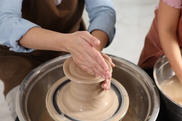Hobby and craft. Mother with her daughter making pottery indoors, closeup