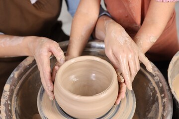 Hobby and craft. Mother with her daughter making pottery indoors, closeup