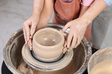 Hobby and craft. Daughter with her mother making pottery indoors, closeup