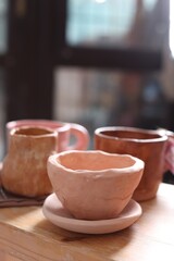 Beautiful pottery on wooden shelf indoors, closeup