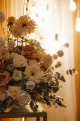 A sophisticated floral composition featuring white, peach, and cream-colored flowers in front of warm yellow curtains. Ideal for interior decor, wedding themes, or elegant branding visuals.