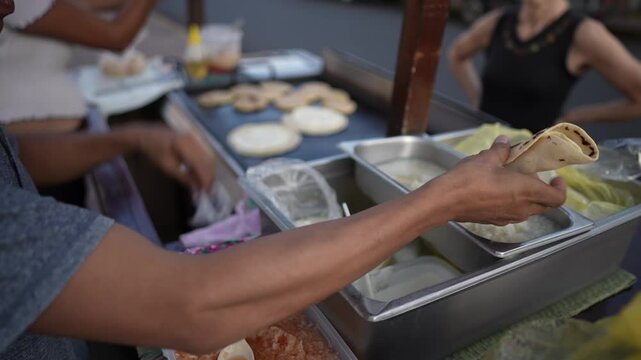 A street vendor serves quesillo in Granada, Nicaragua. Tourists are exploring the bustling market, enjoying authentic Central American cuisine at sunset.