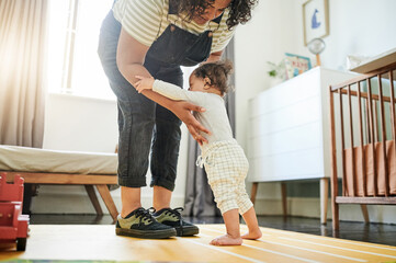 Mother, baby and learning to walk in home, education and bonding in house nursery. Care,...