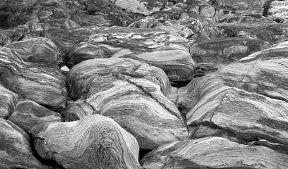 Black and white abstract background of natural rock shapes and patterns with swirls and lines running through the granite