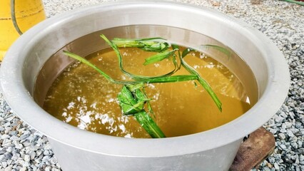 a cauldron of sugar water mixed with cooked pandan leaves for use as a wedding drink. making caramel. Cooking sugar to caramelize. caramelize sugar