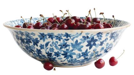 Fresh red cherries overflowing a blue and white bowl on transparent background