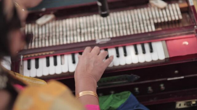 Shot of a musician playing harmonium at an Indian Wedding function in India
