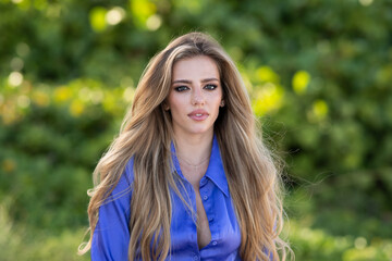 Naklejka premium Beauty woman face. Beautiful tender young woman look sensual outdoor. Charming elegance beauty sexy lady on spring or summer background. Tenderness portrait of young woman with make up.