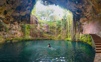 Beautiful sunlight in a Ik-Kil Cenote - Lovely cenote in Yucatan Peninsulla with transparent waters and hanging roots. Chichen Itza, Mexico