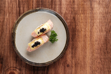 Seared Salmon Sushi with Cheese and Caviar Topping Served on a Plate