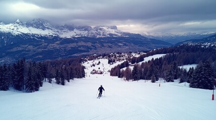 Skier descends snowy mountain slope, village & Alps backdrop, winter sports