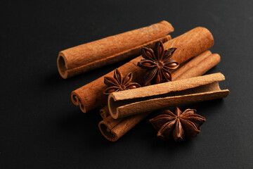 Aromatic cinnamon sticks and star anise on black background