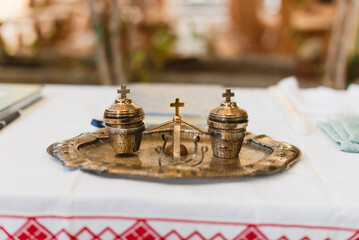 Traditional religious artifacts displayed on a decorative tray during baptism