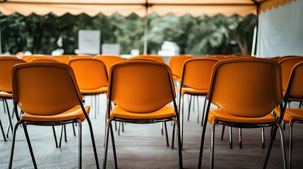 A row of empty chairs arranged under a tent for public health screenings