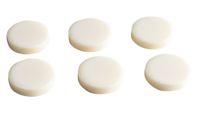 Round milk tablets arranged neatly isolated on cut out PNG or transparent background. Vitamins and calcium nourish body. Emphasizing their smooth texture and creamy color. Health and dietary product.