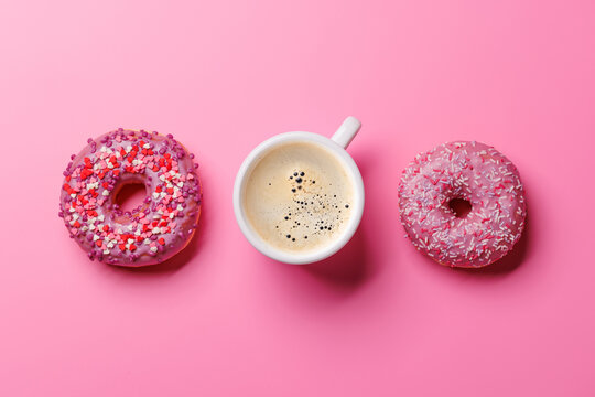 An assortment of vibrant donuts with colorful toppings and a coffee cup