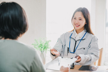 作業着を着た女性がお客様に案内する
A woman wearing work clothes guides customers