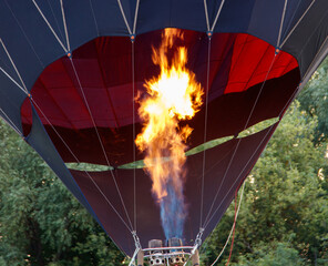Obraz premium A hot air balloon with a red and orange striped body is floating in the sky