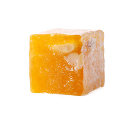 Yellow fruit-flavored confectionary cube with nut pieces on a white background