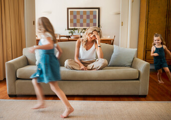 ADHD, motion blur and stress of mother with children running in living room of home for...