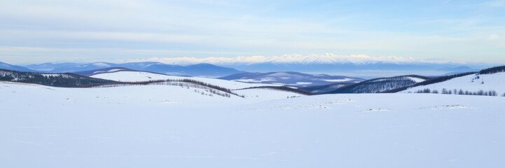Snow-covered landscape with rolling hills and a distant mountain range in the background, winter, rolling hills, range